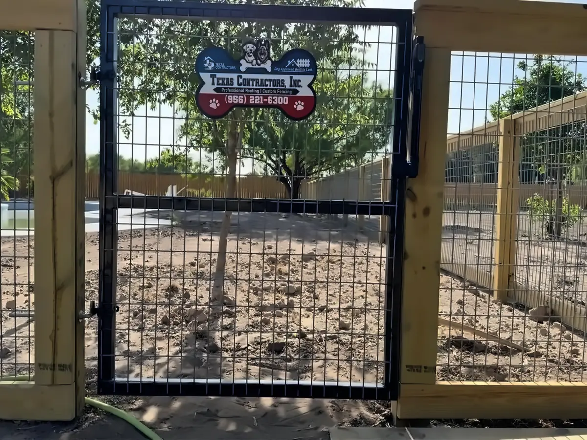 Heavy duty black metal gate with horse panel wire on a custom fence built for a dog training facility in McAllen, Texas